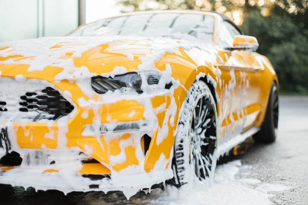 Demonstrating the two bucket washing method in Southampton to prevent car paint scratches and maintain vehicle shine.